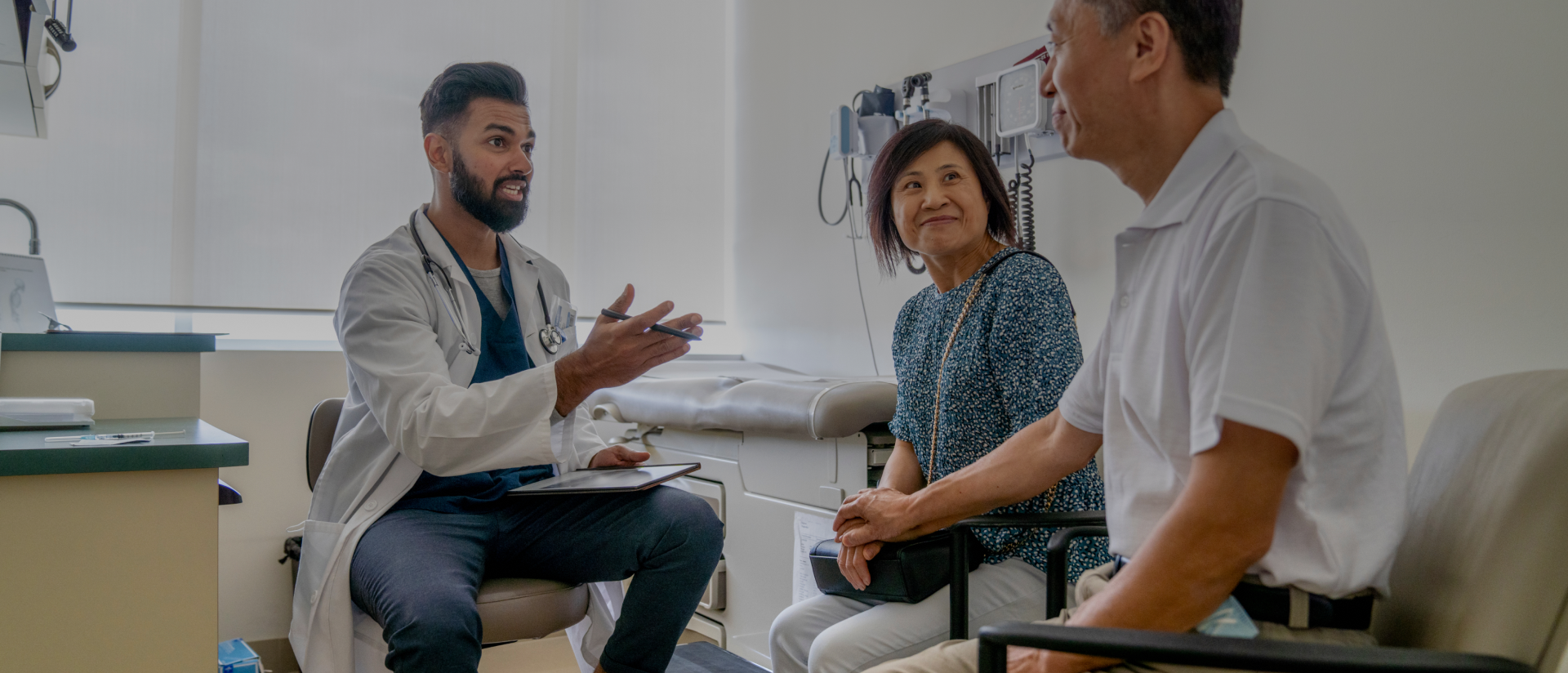 Ein Arzt im Gespräch mit einem Patienten und seiner Angehörigen