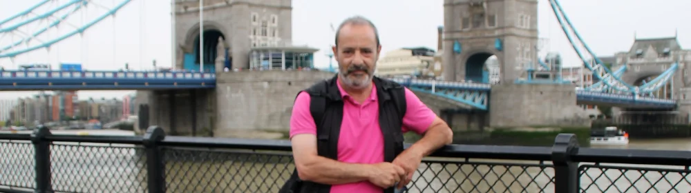 橋を背景に手すりのそばに立っている男性