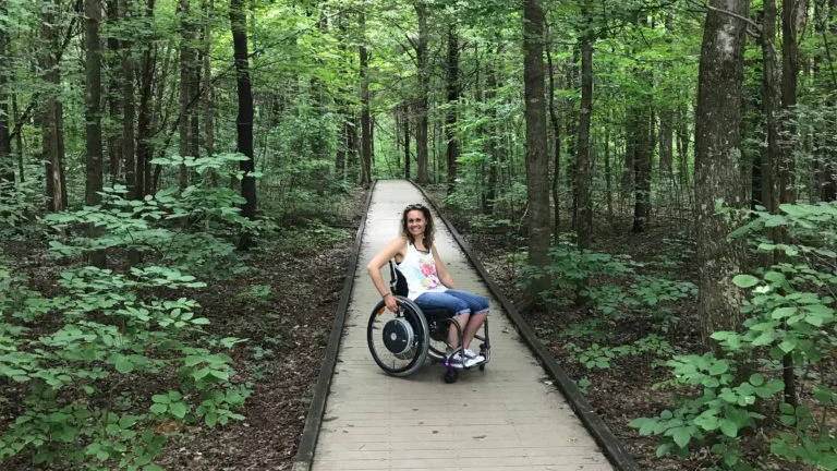 Arlene in sedia a rotelle su un sentiero nel bosco