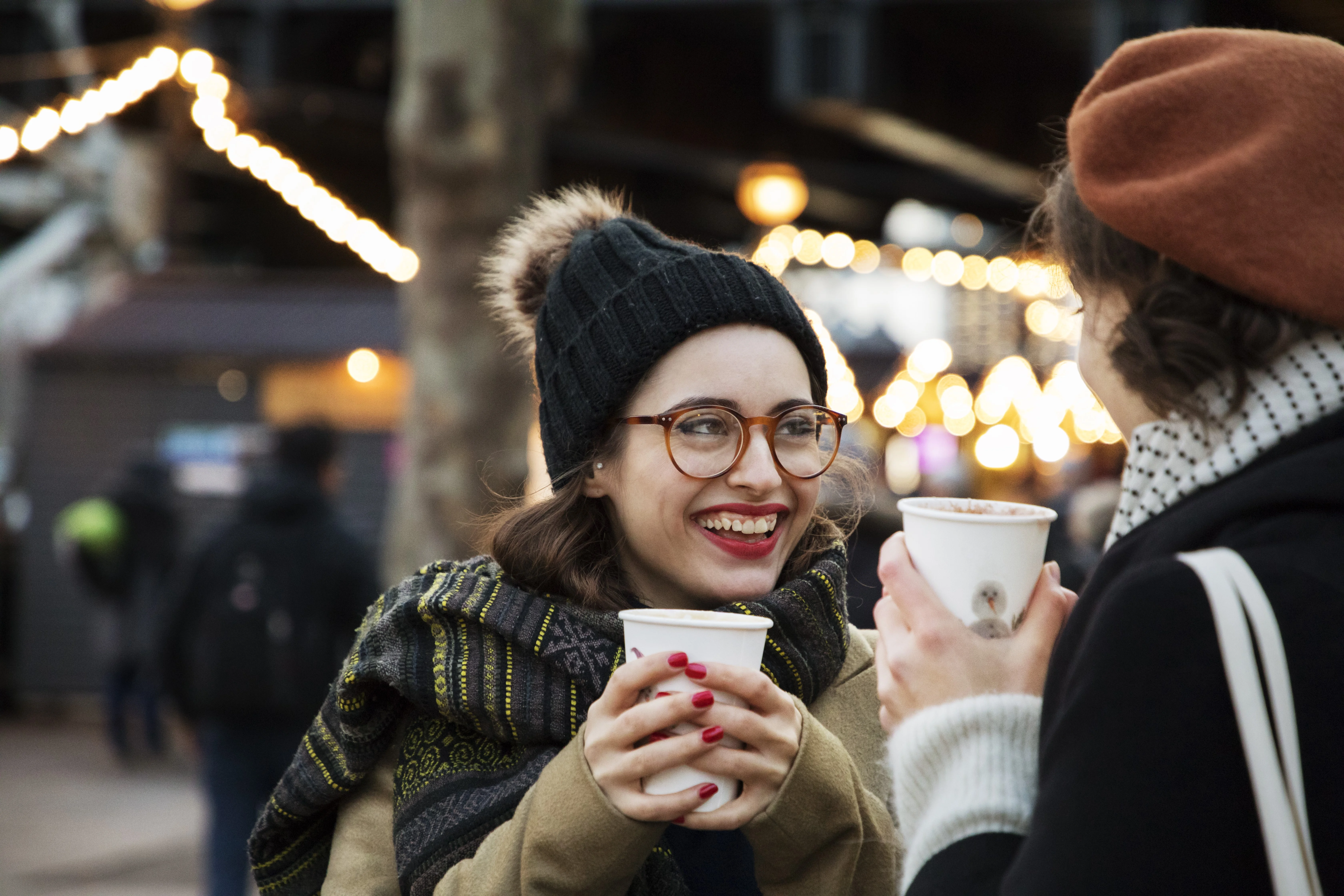 uma pessoa segurando um copo e um celular